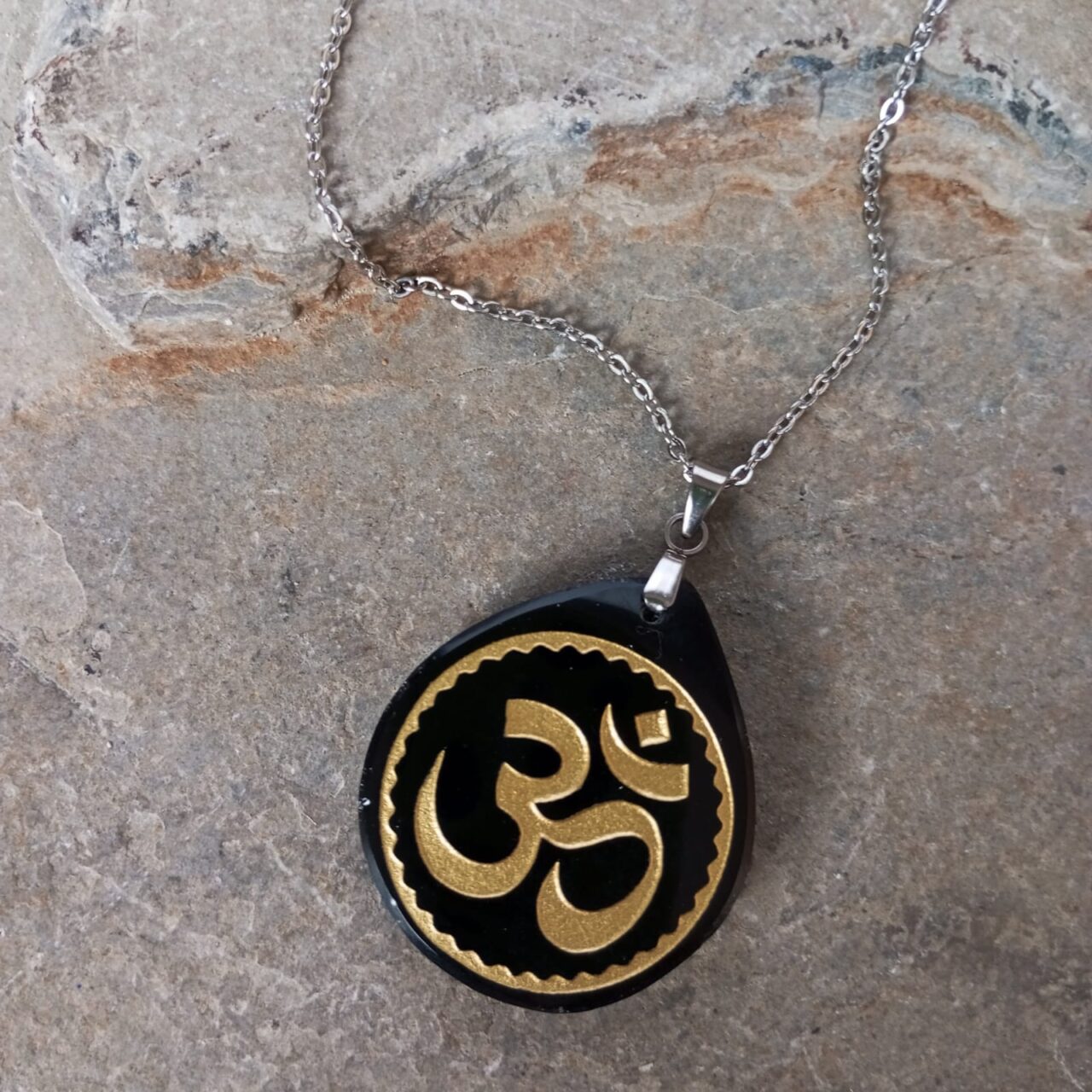 dije en piedra obsidiana grabado simbolo om dorado 12581