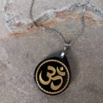 Dije en Piedra Obsidiana Grabado Símbolo Om Dorado